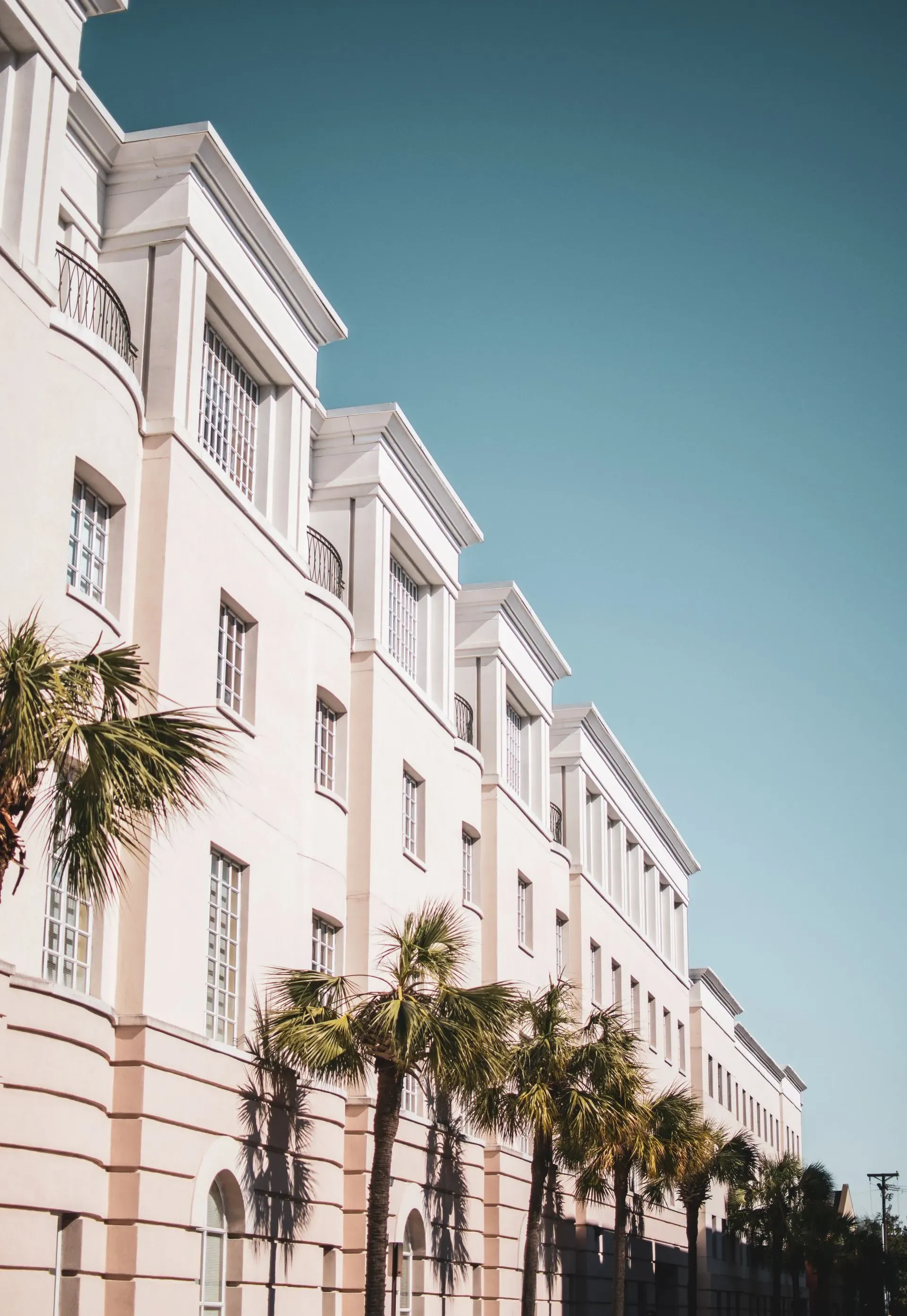 Miami Beach condo facade with palm trees and exterior walls where humidity and water can travel.